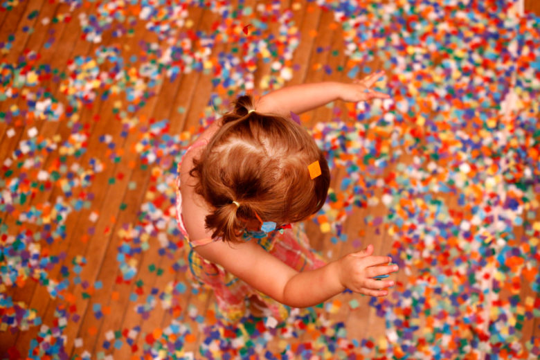 Overhead view of small girl with pigtails playing in confetti