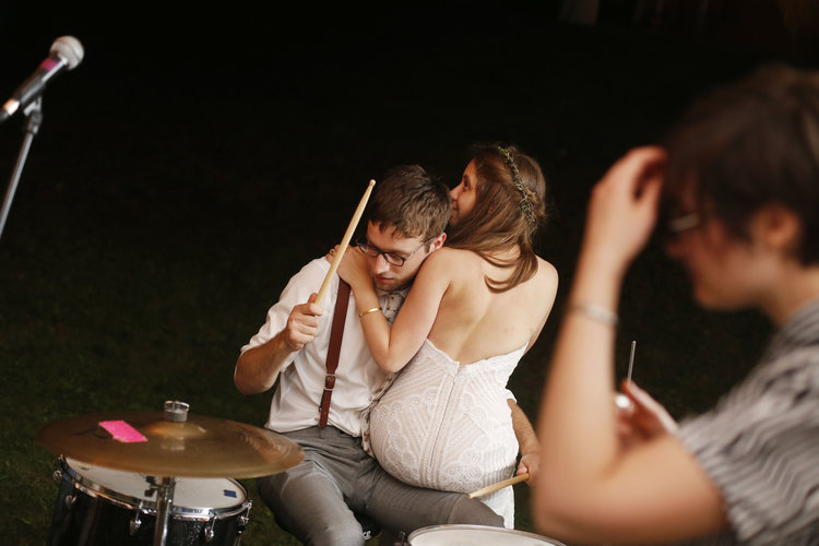 bride sitting in lap of drummer at drum kit