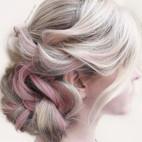 woman with platinum, pink, and dark-streaked hair, piled on the side in a low twisted braid
