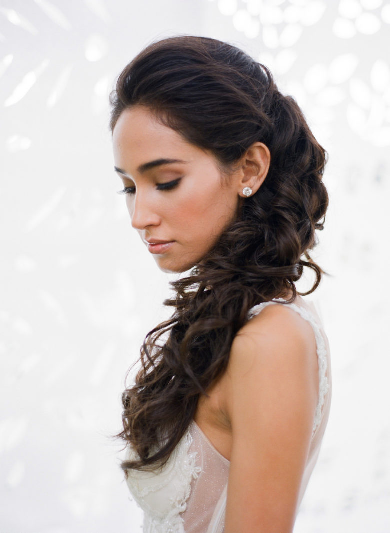 woman with long dark hair with loose curls cascading down shoulder
