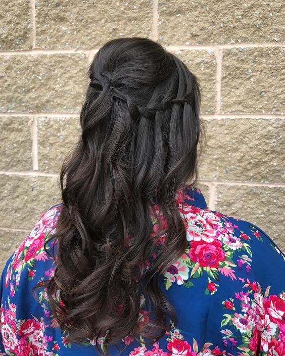 woman with long dark brown ombre hair in a waterfall braid from front to back, with loose curls