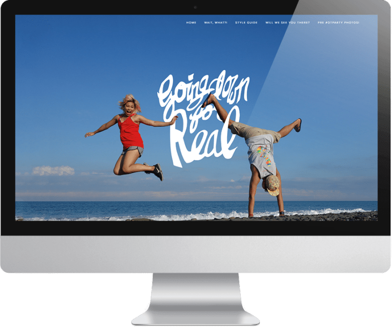 Computer monitor showing wedding website with couple jumping and doing a handstand with words "going down for real" overlaid.