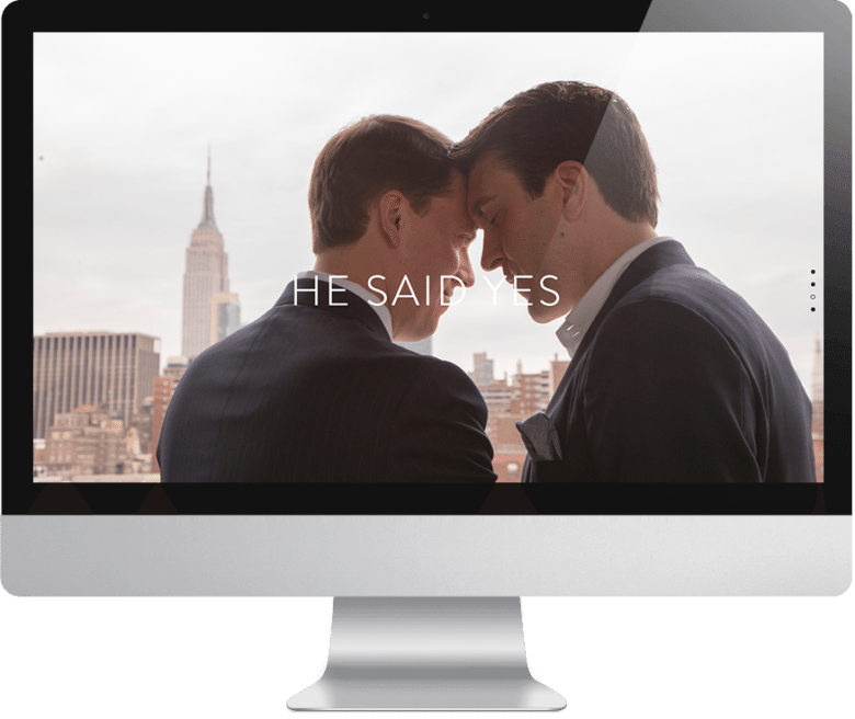 Computer monitor showing Squarespace wedding website with gay couple with their heads together. Words "he said yes" overlaid.