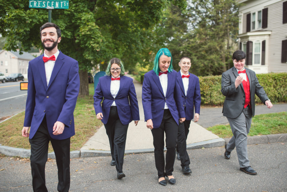 mixed gender bridal party in black pants and purple blazers crossing street